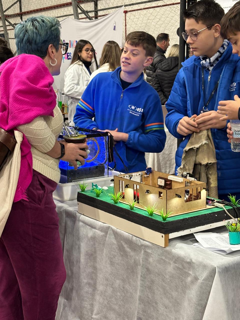 Estudantes interagindo com visitantes na feira